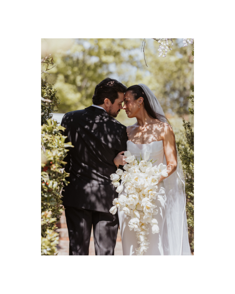 Romantic portrait of the bride and groom embracing beneath the gardens at The VanLandingham Estate in Charlotte.