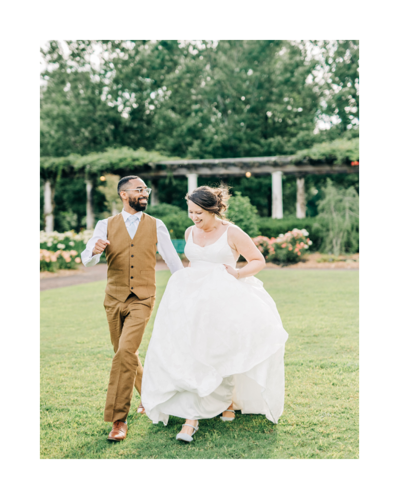 Bride and groom laugh while walking across the lawn together after their wedding ceremony at Daniel Stowe Botanical Garden in Belmont, North Carolina.