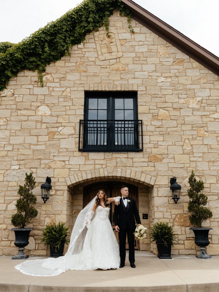 Bride and groom posing in front of a French-inspired wedding venue, Silver Oaks Chateau.