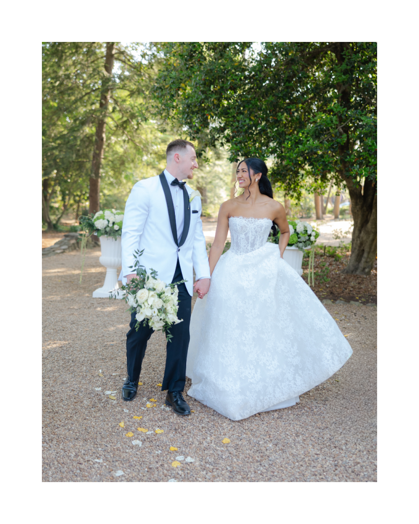 Bride and groom walk hand in hand through the gardens of The VanLandingham Estate following their ceremony in Charlotte.