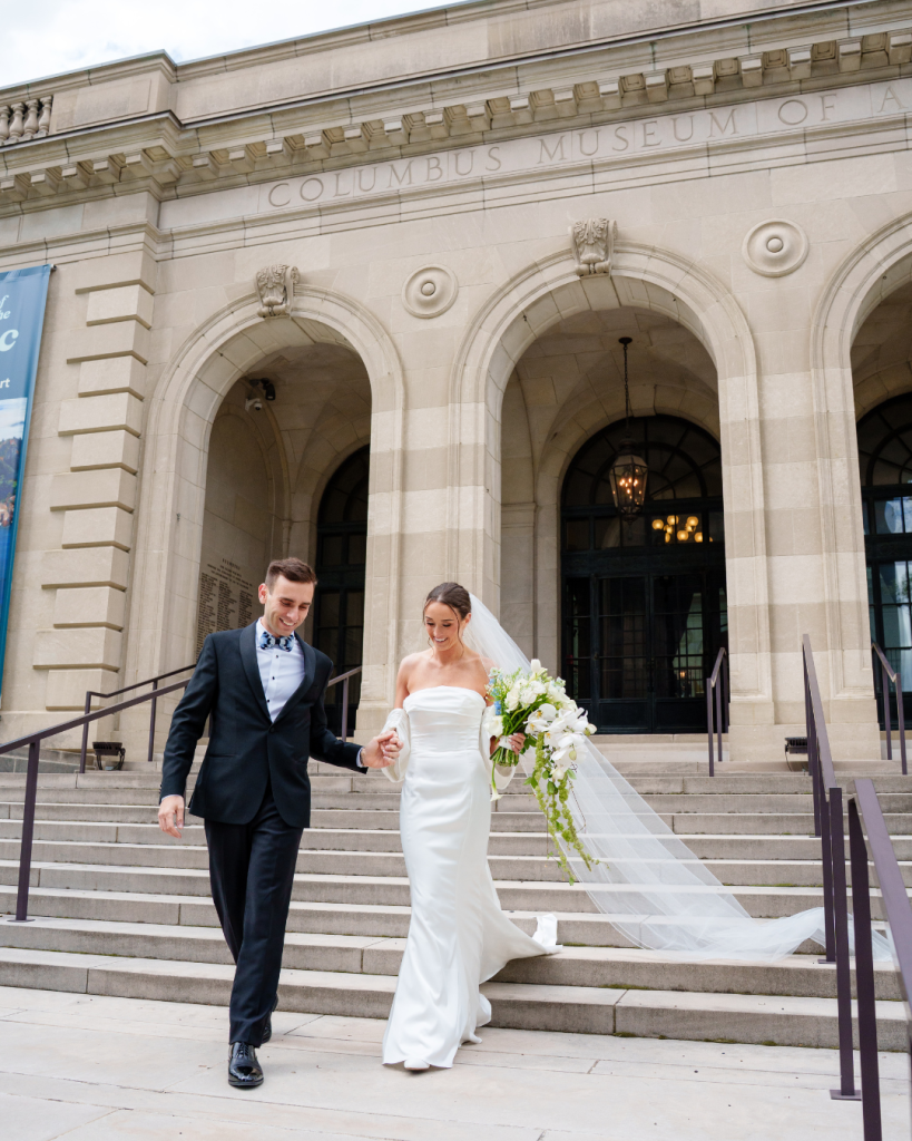Bride and groom walking down the steps of the Columbus Museum of Art after their wedding