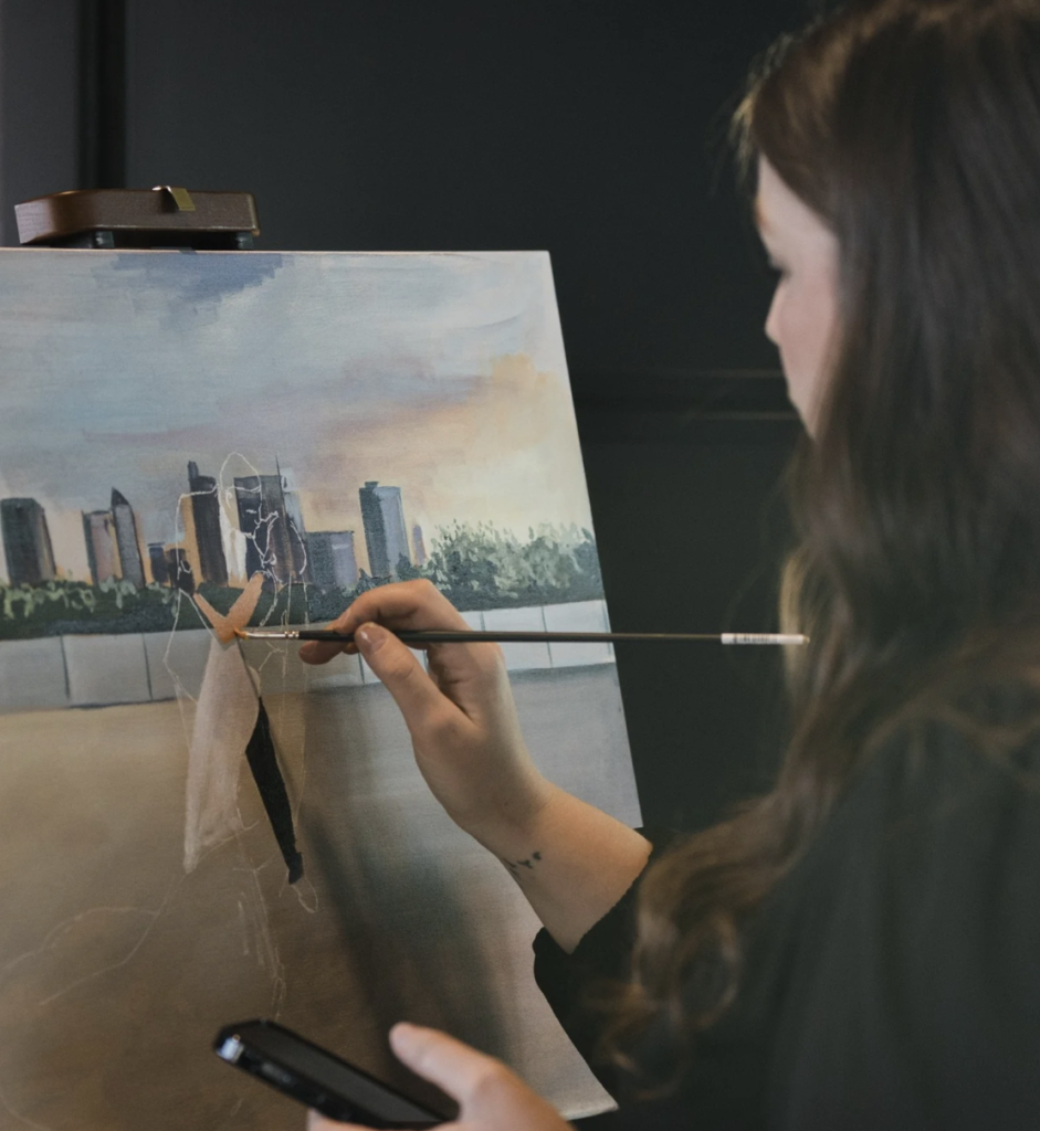 Fine Arts by Logan artist creating a custom live wedding painting featuring a couple against the Columbus, Ohio skyline.