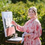 Live wedding painter working outdoors on a custom wedding portrait.