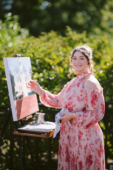 Live wedding painter working outdoors on a custom wedding portrait.