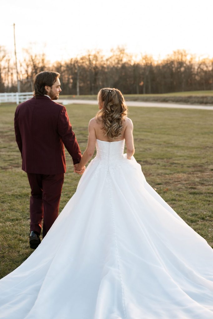 Bride and groom walking into the sunset with bride's hair done by LUX Studio.
