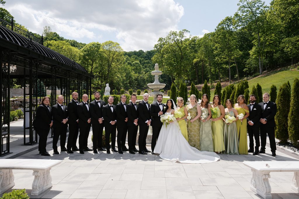 Bridal party posing in front of European style fountain at Knotting Hills Wedding Venue and Resort.