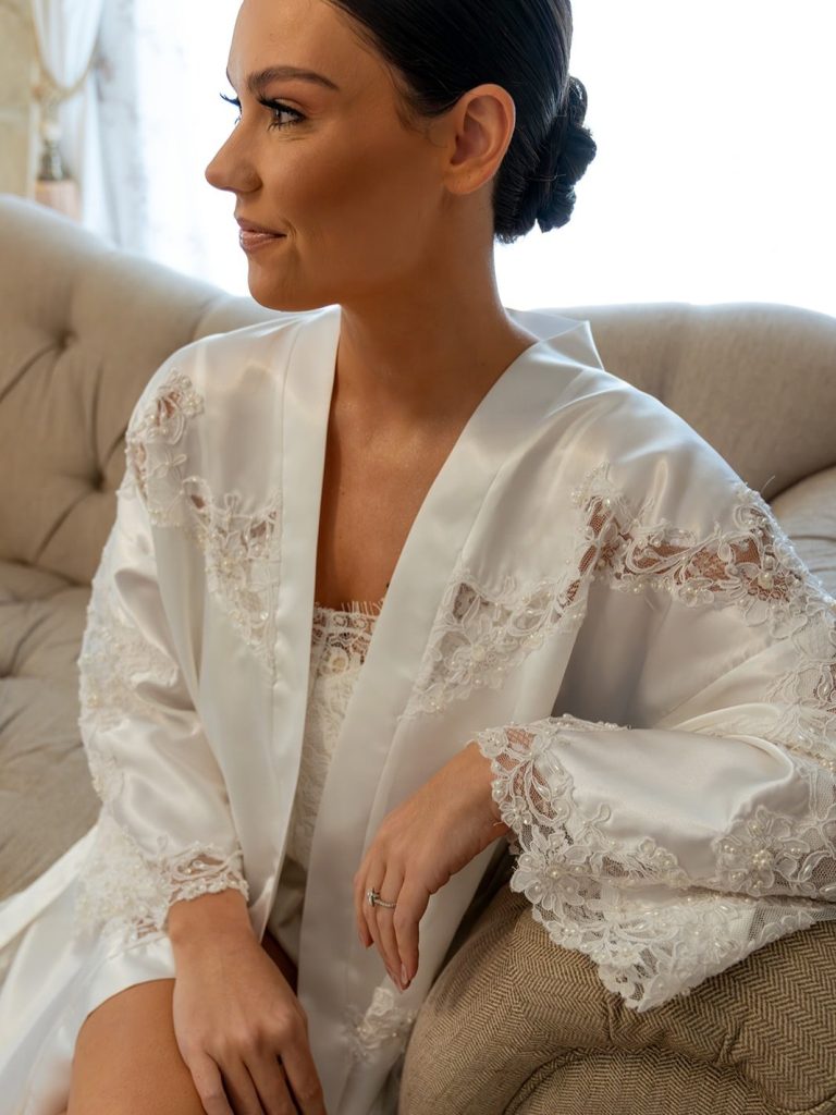 Bride wearing a getting ready robe crafted by Still Her Dress.