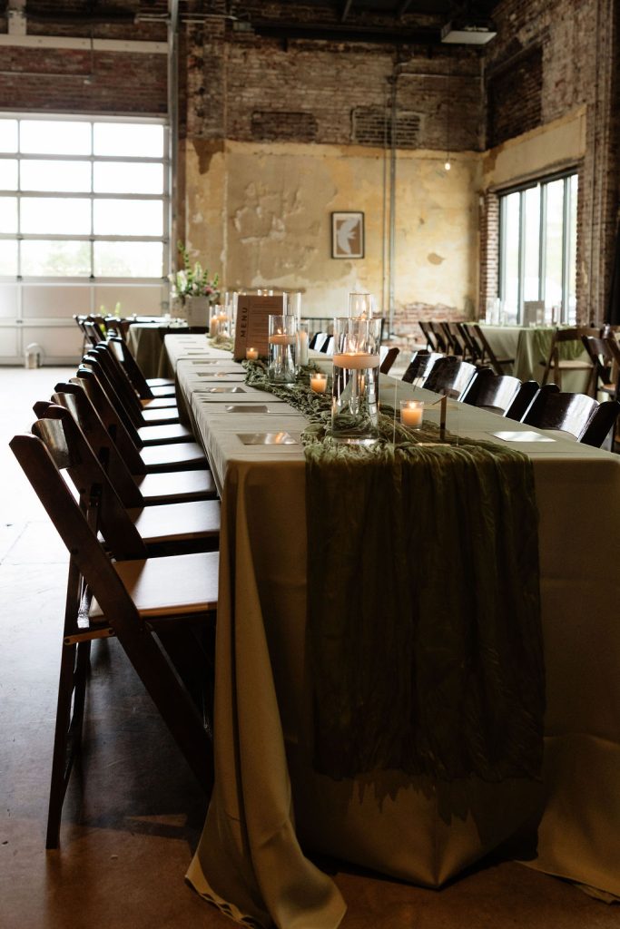 Long reception table with olive green table cloths. Coordinated by Coordinating with Catherine.