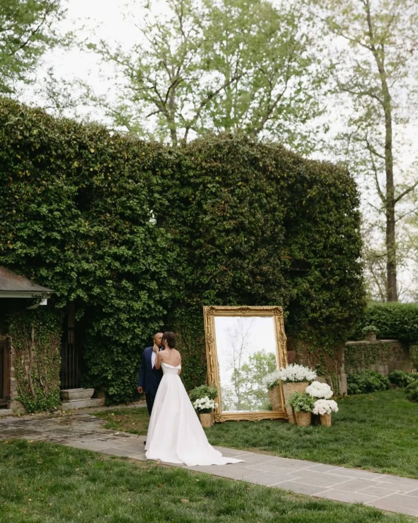 husband and wife first look at greenery ivy wall at luxury wedding venue in northern virginia