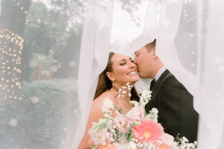 groom kissing bride underneath wedding veil light and airy wedding style northern virginia