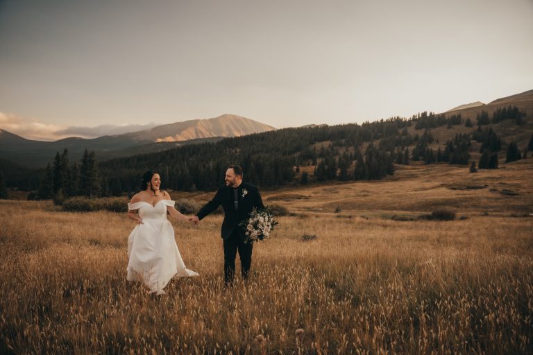 bride and groom running through prairie with mountains in the background, warm editing style photographer northern virginia