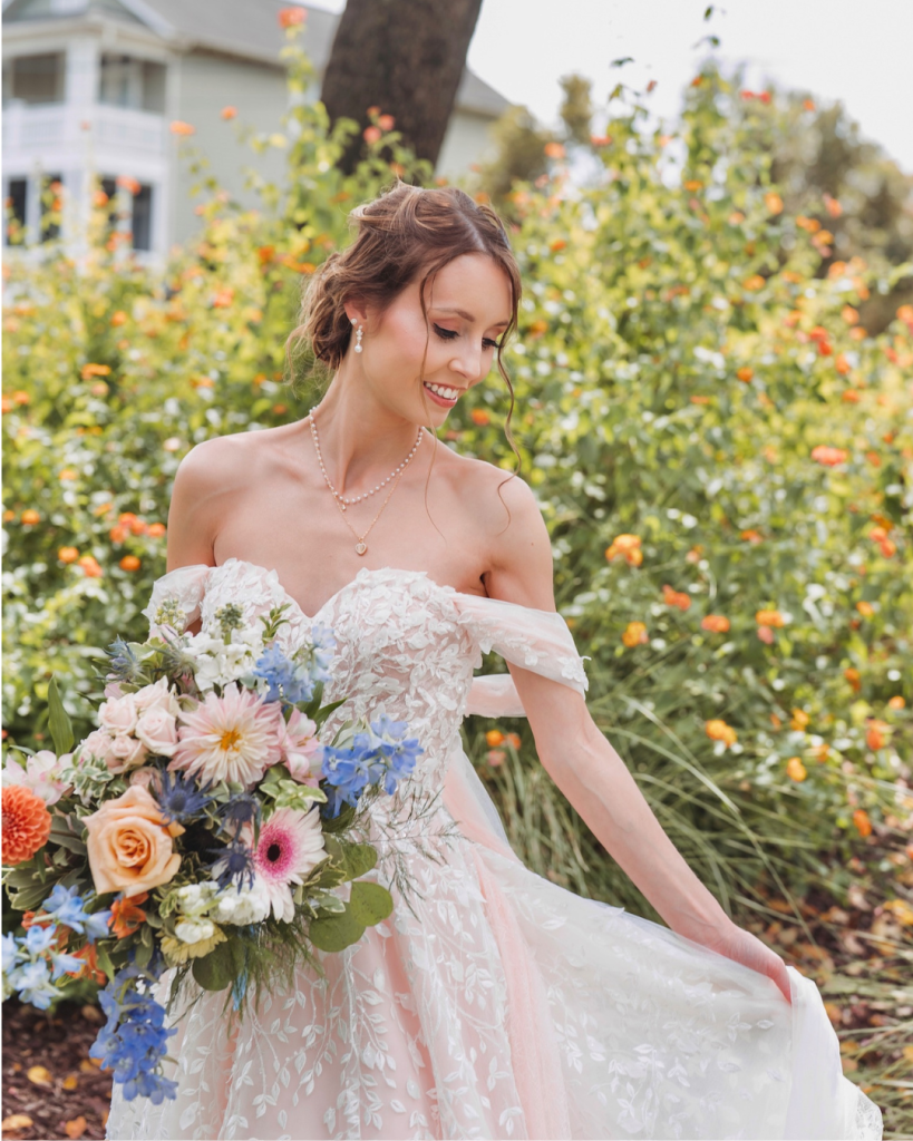 Bride holding a colorful bouquet while wearing a floral appliqué wedding gown at The Riverwalk Event Venue in Rock Hill, South Carolina. Featured on Wed Society Charlotte.