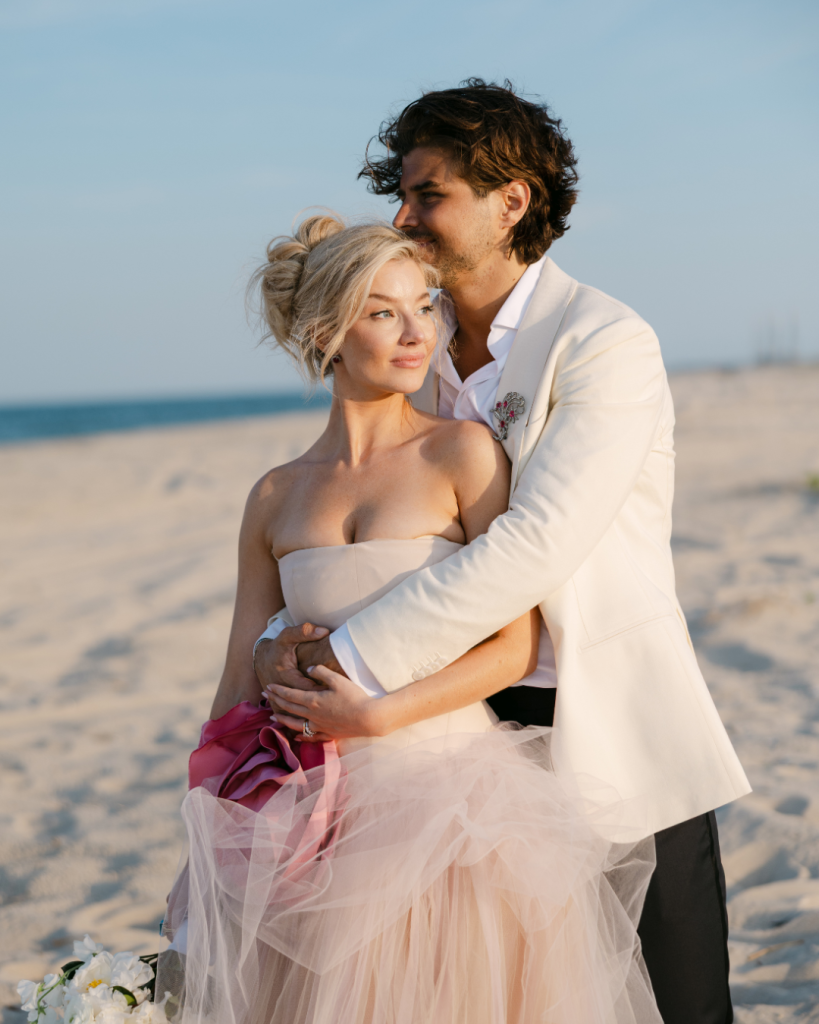 Bride and groom embrace on the sand during their summer Rehoboth Beach wedding in Delaware.
