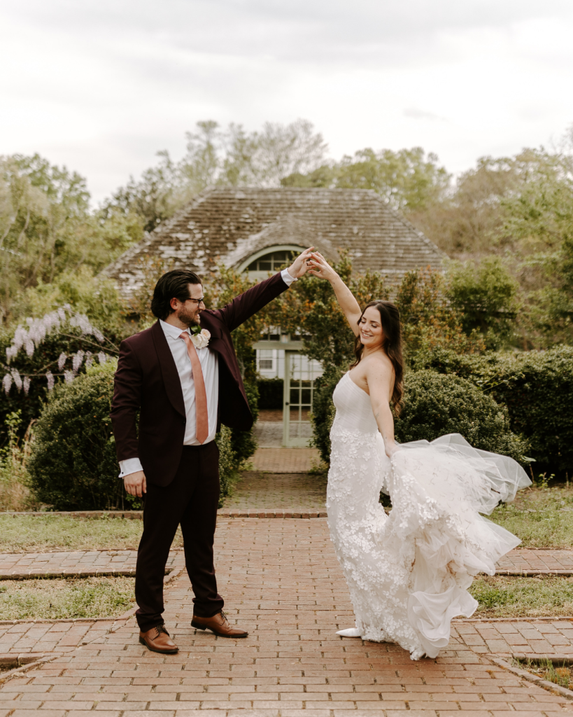 Bride twirls with groom in the formal gardens at Van Landingham Estate during spring wedding portraits in Charlotte, NC.