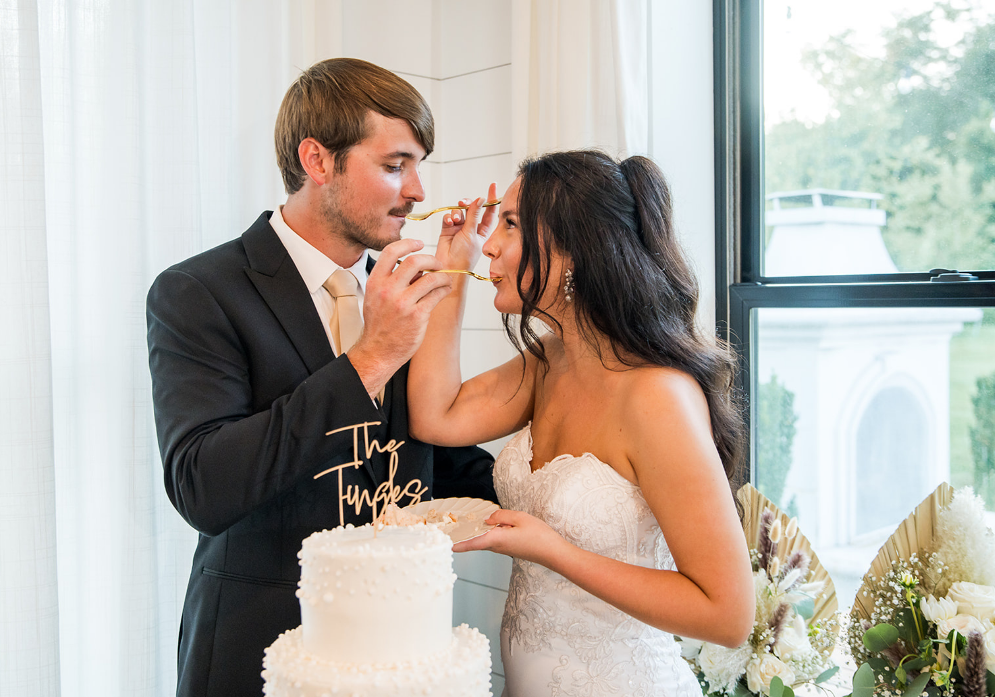 Bride and groom feeding each other wedding cake during their reception on Maryland's Eastern Shore.
