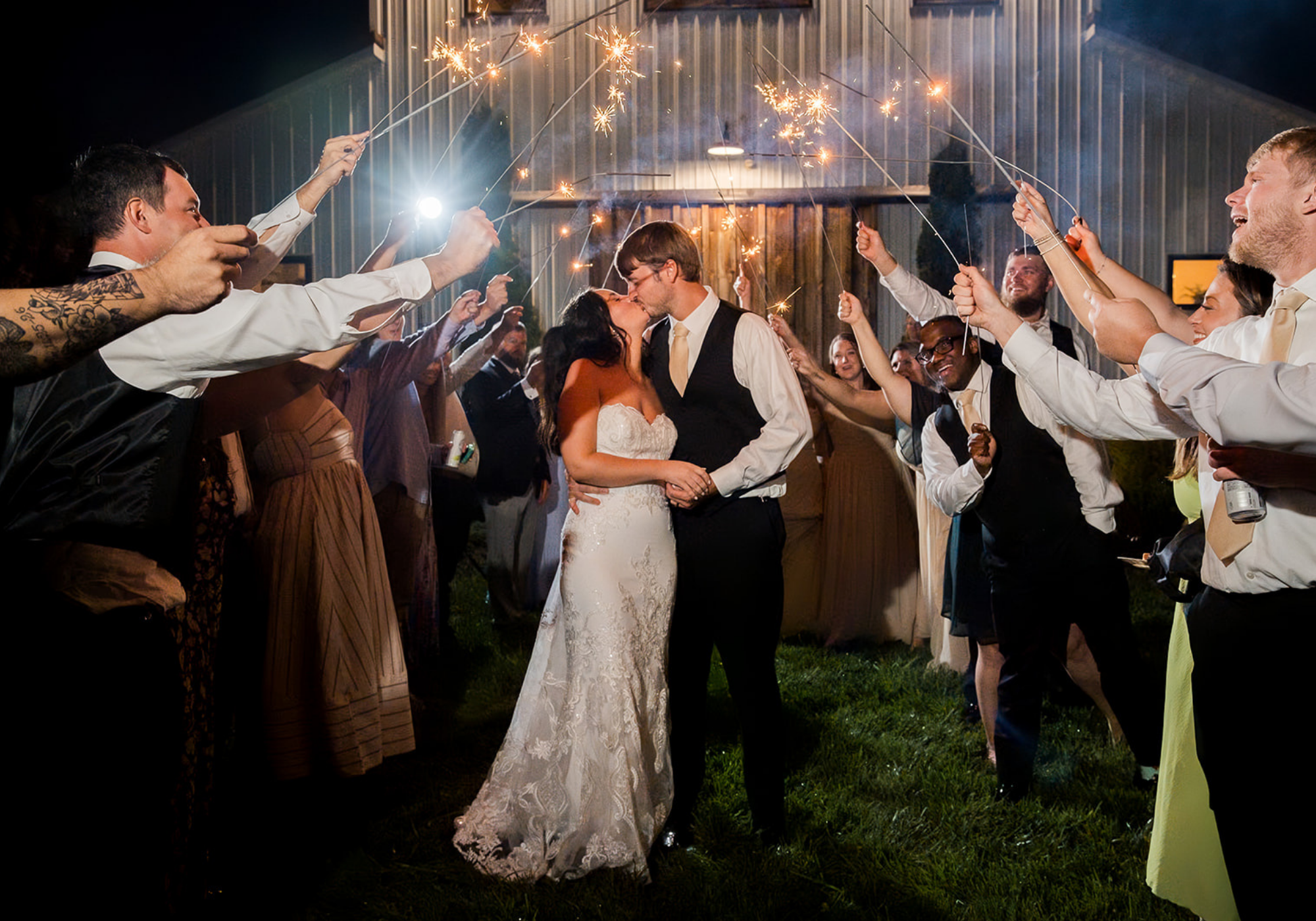 Bride and groom sharing a sparkler exit surrounded by cheering wedding guests during a wedding celebration in Delaware.