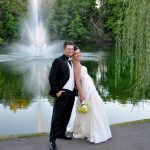 Newlywed couple posing beside a tree-lined pond and fountain at Brookside Golf & Country Club in Columbus, Ohio.