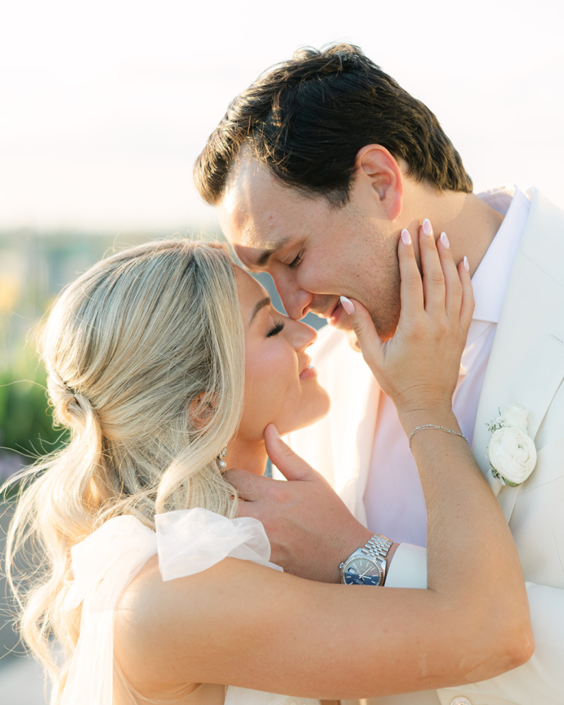 Reagan and Wes embrace during golden-hour portraits in their coordinated white wedding attire.