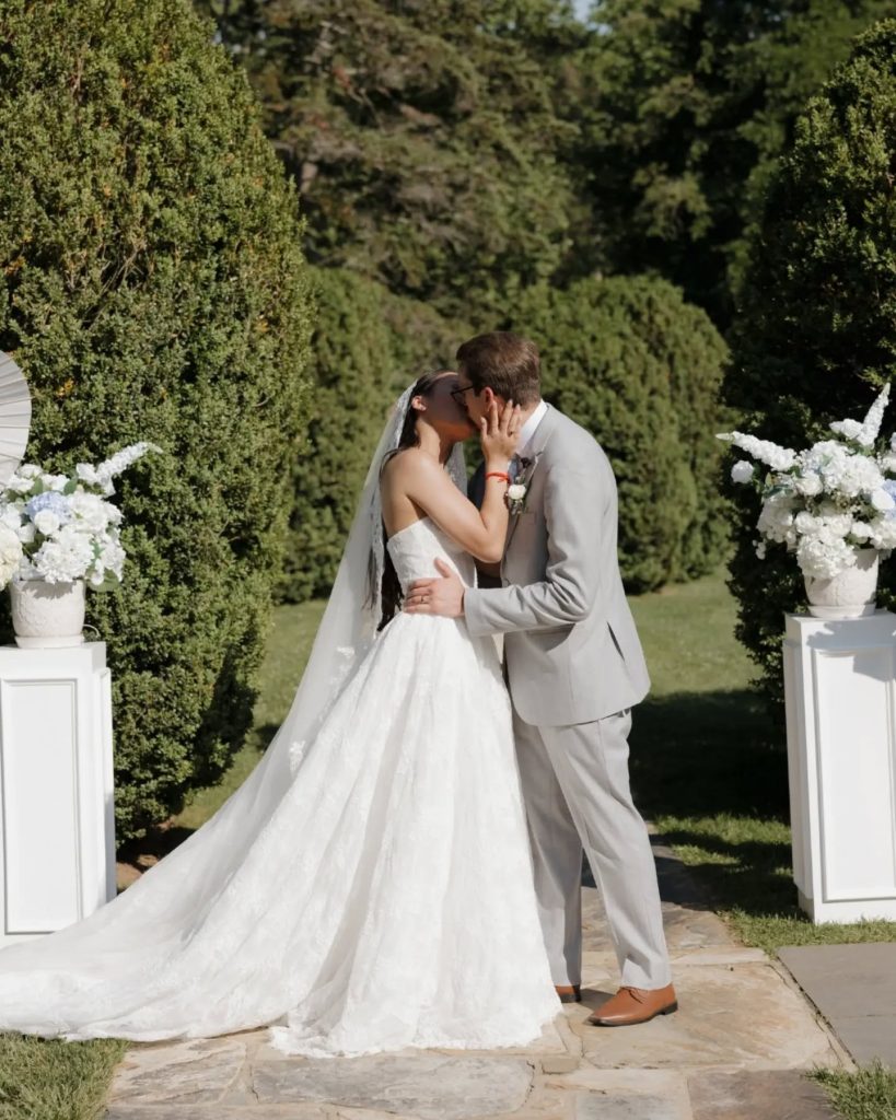 couple at wedding ceremony first kiss ourdoor garden wedding