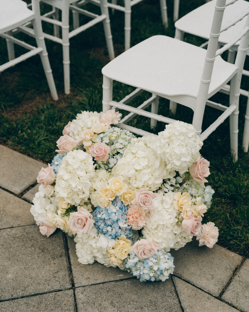 white, blue, and pink wedding flowers aligned wedding aisle at wedding ceremony