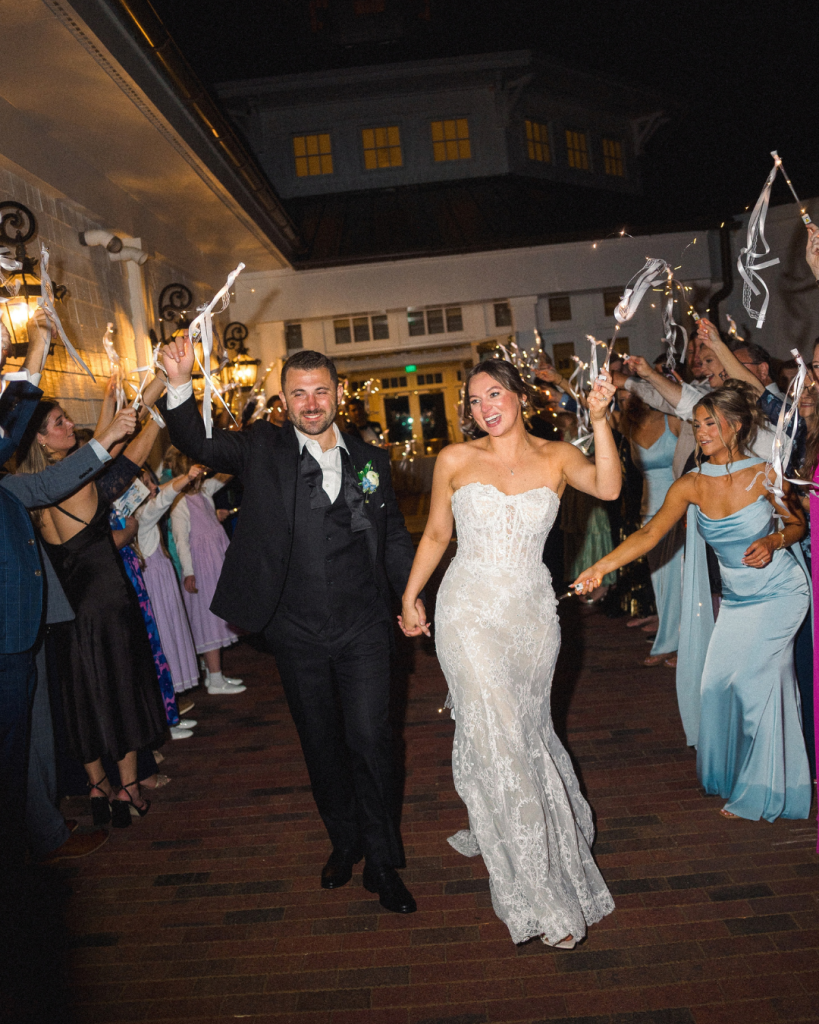 Hannah and Johnathan walk through a sparkler send off surrounded by wedding guests at the end of their Mooresville wedding.