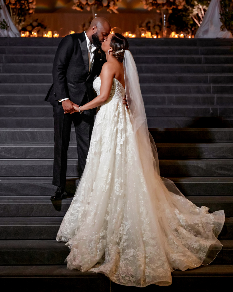 Joy and Edward’s reception details including elevated white florals, crystal glassware, candlelight and a sculptural white wedding cake.