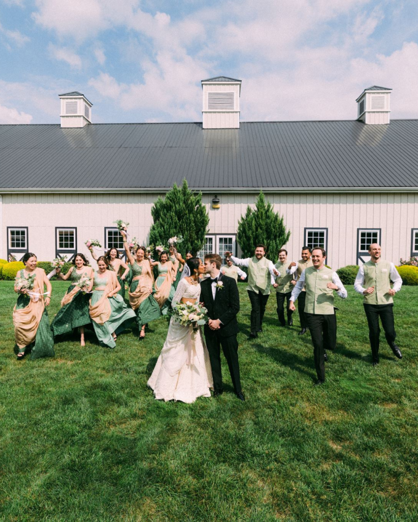 wedding party outside infront of white barn