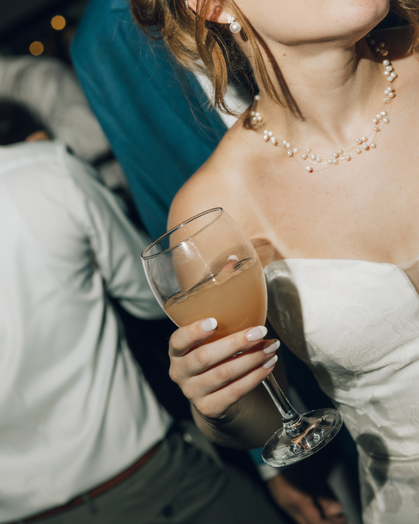bride holding signature drink during dancing reception