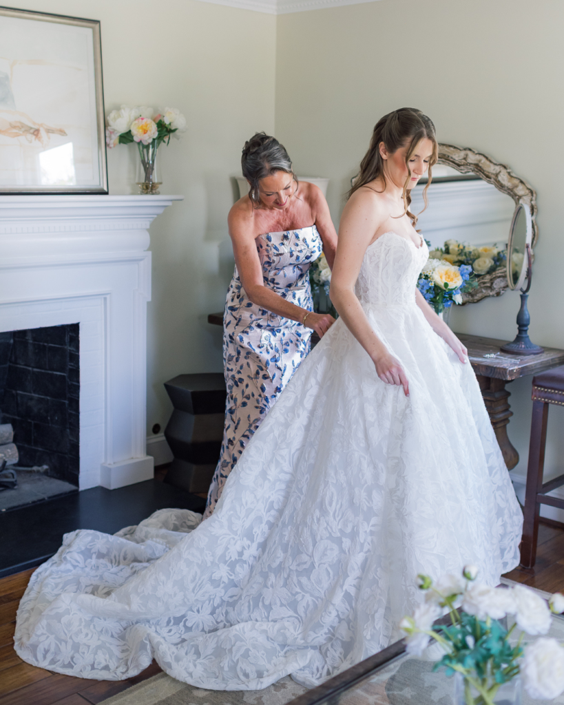 mom helping bride put on wedding dress before wedding ceremony. getting ready moments