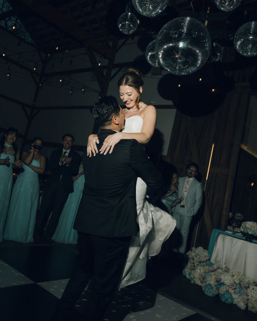 groom lifting bride during dancing at wedding reception