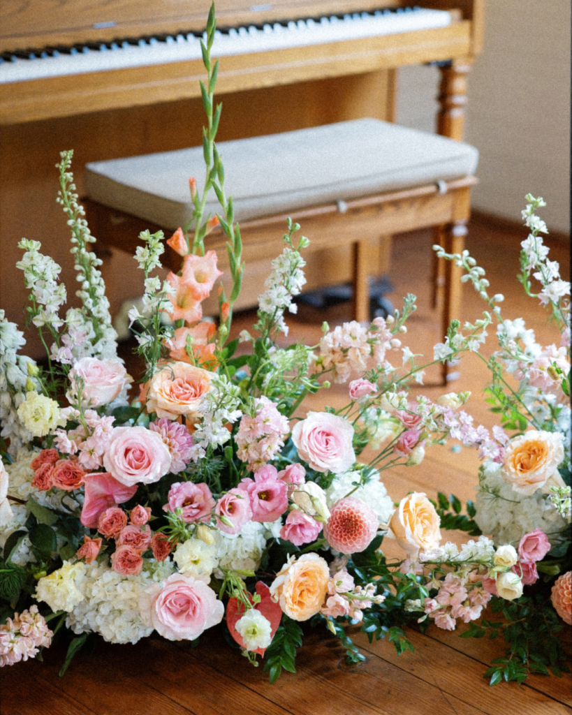 Colorful pink, peach and white wedding florals arranged inside the Chapel at Morning Star for Lauren and Peyton’s ceremony.