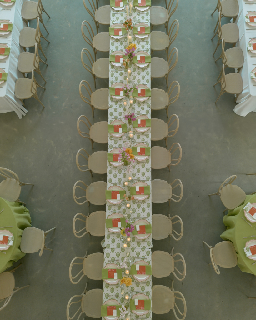 Colorful wedding reception tables at The Lumen House feature bright floral arrangements, patterned linens, candles, colorful glassware and decor and rentals from Curated Events Charlotte.