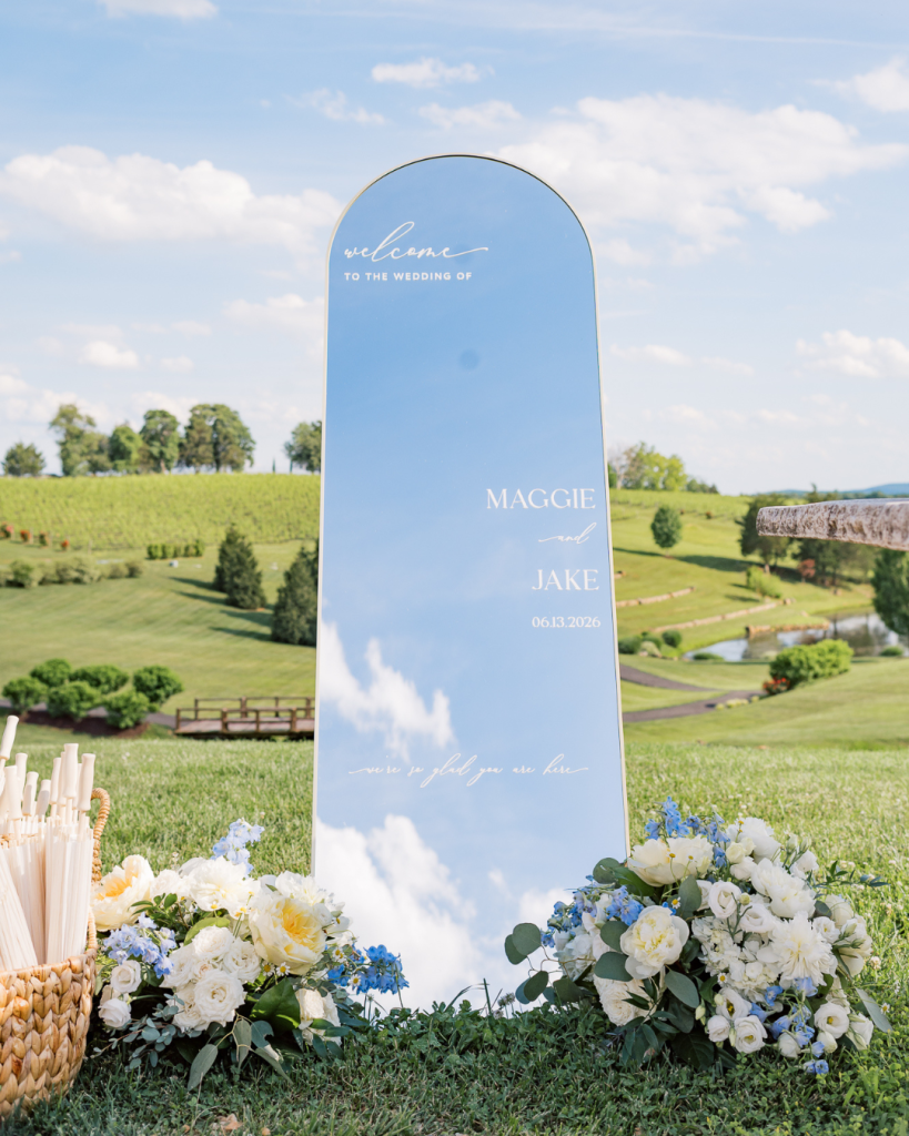 mirror welcome sign for outdoor wedding with white florals