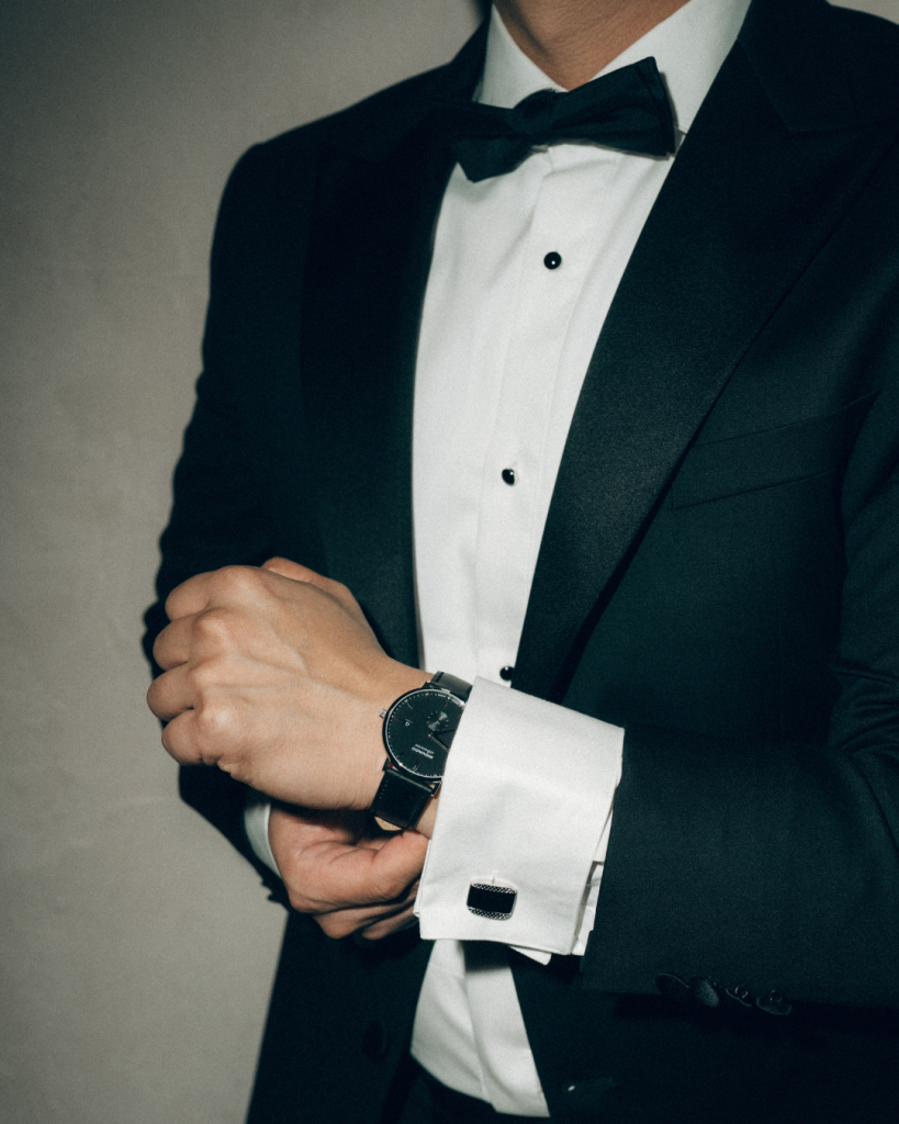 groom putting on watch during morning of wedding black tux upscale wedding
