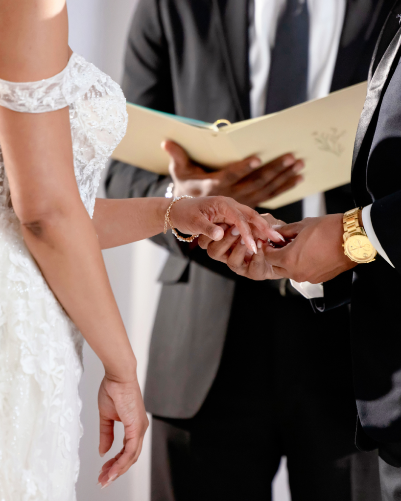 Close view of Joy and Edward exchanging rings during their Charlotte wedding ceremony.