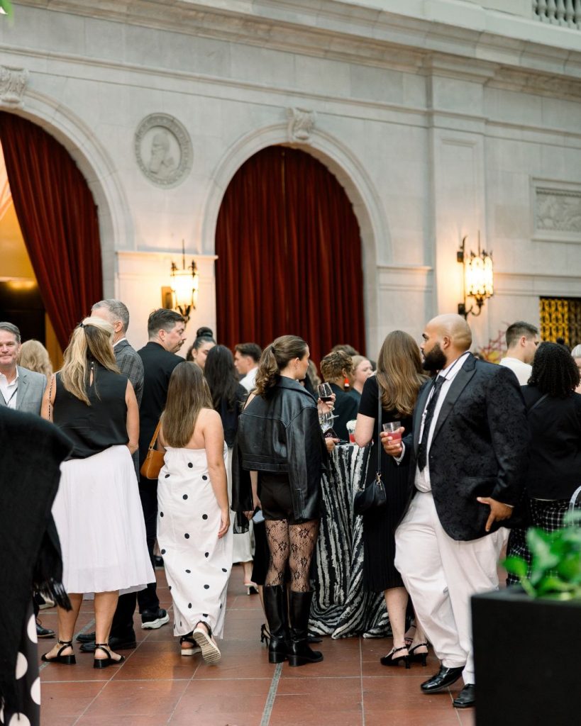 Guests mingle beneath stone arches and red velvet curtains at the Columbus Museum of Art.
