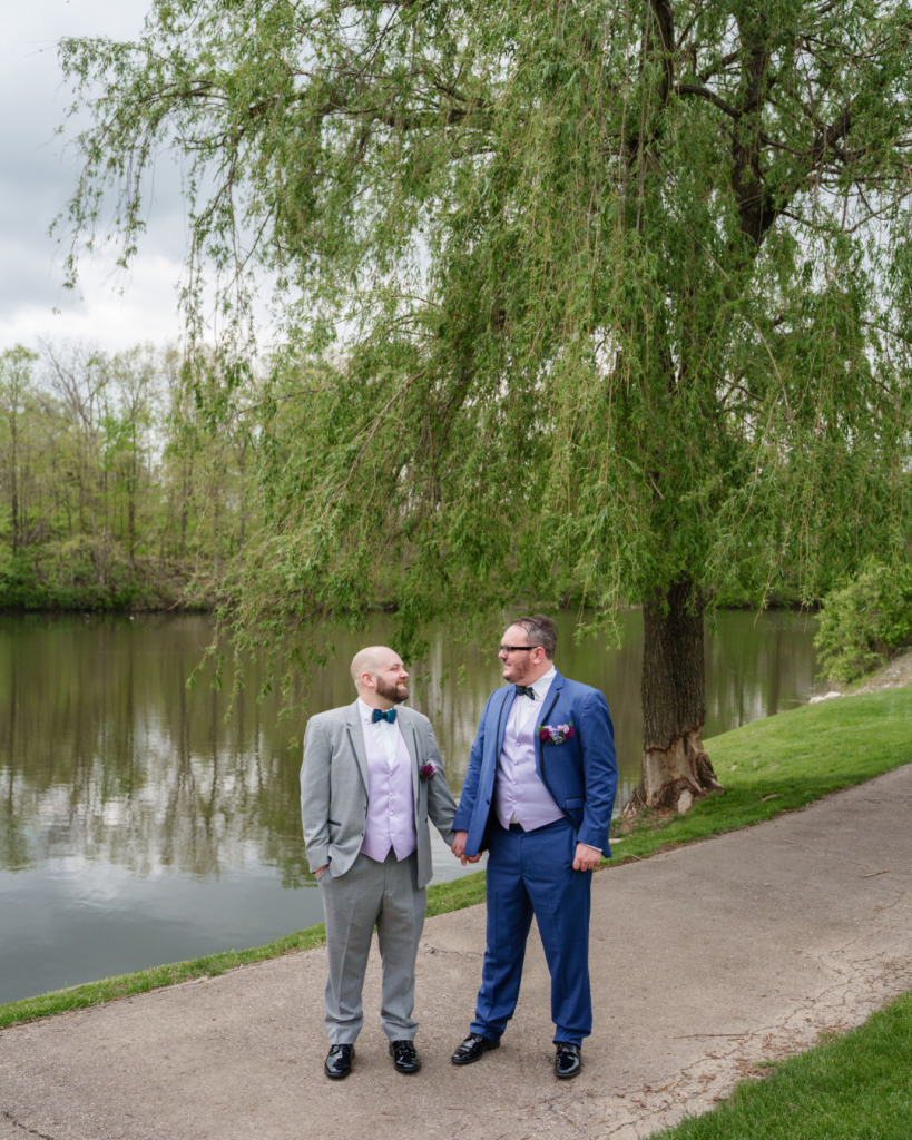 Outdoor wedding ceremony at Brookside Golf & Country Club with navy draping, colorful flowers and petals lining the aisle.
