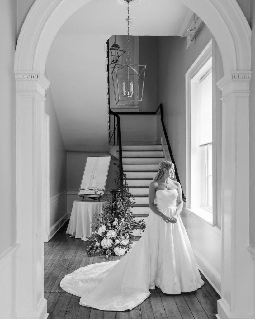 Bride in wedding gown standing on the staircase at Gadsden House in downtown Charleston