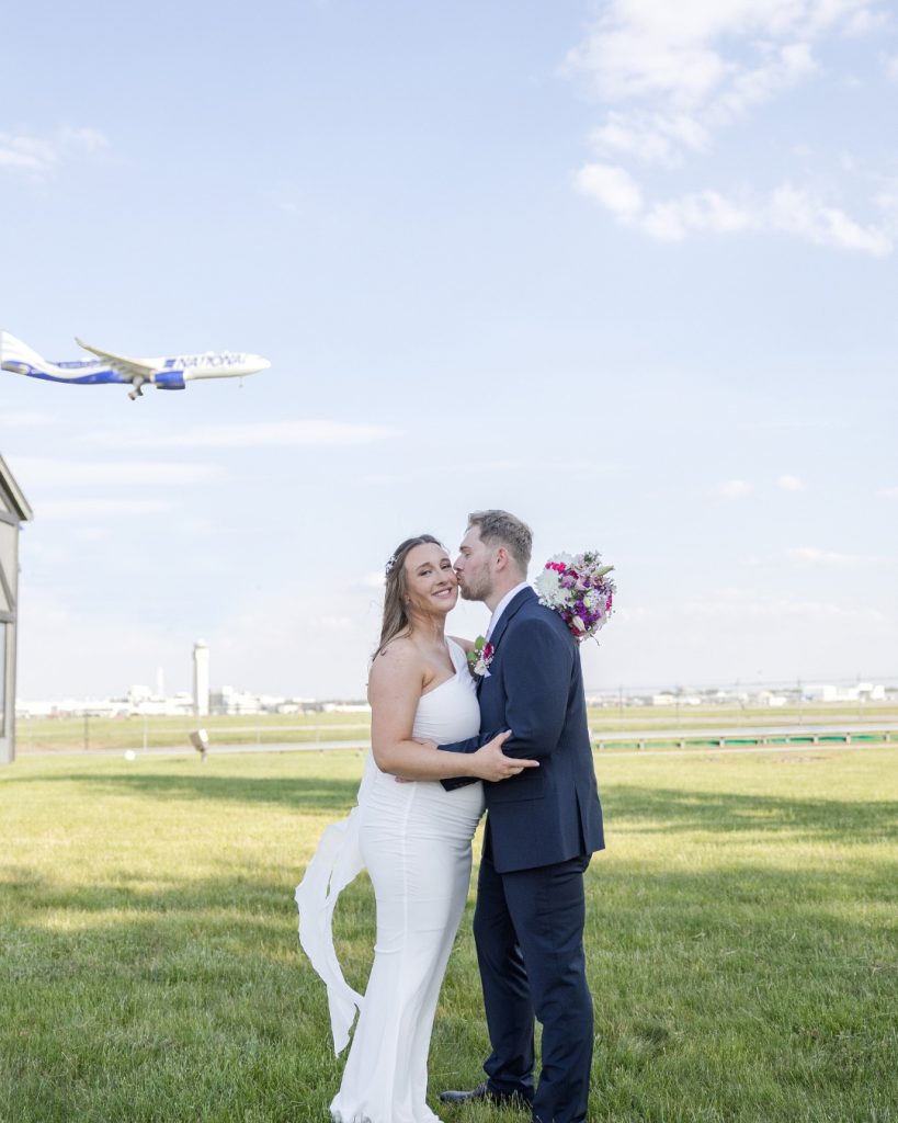 Bride and groom photo with a plane landing at The Aviator in Cleveland