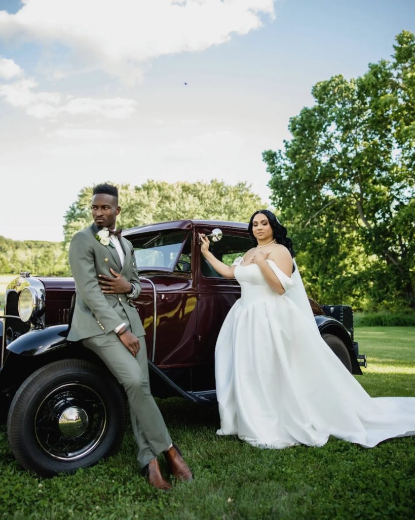 bride and groom during portrait session with classic car at riverside on the potomac. bride in princess cut wedding dress and groom in olive green suit