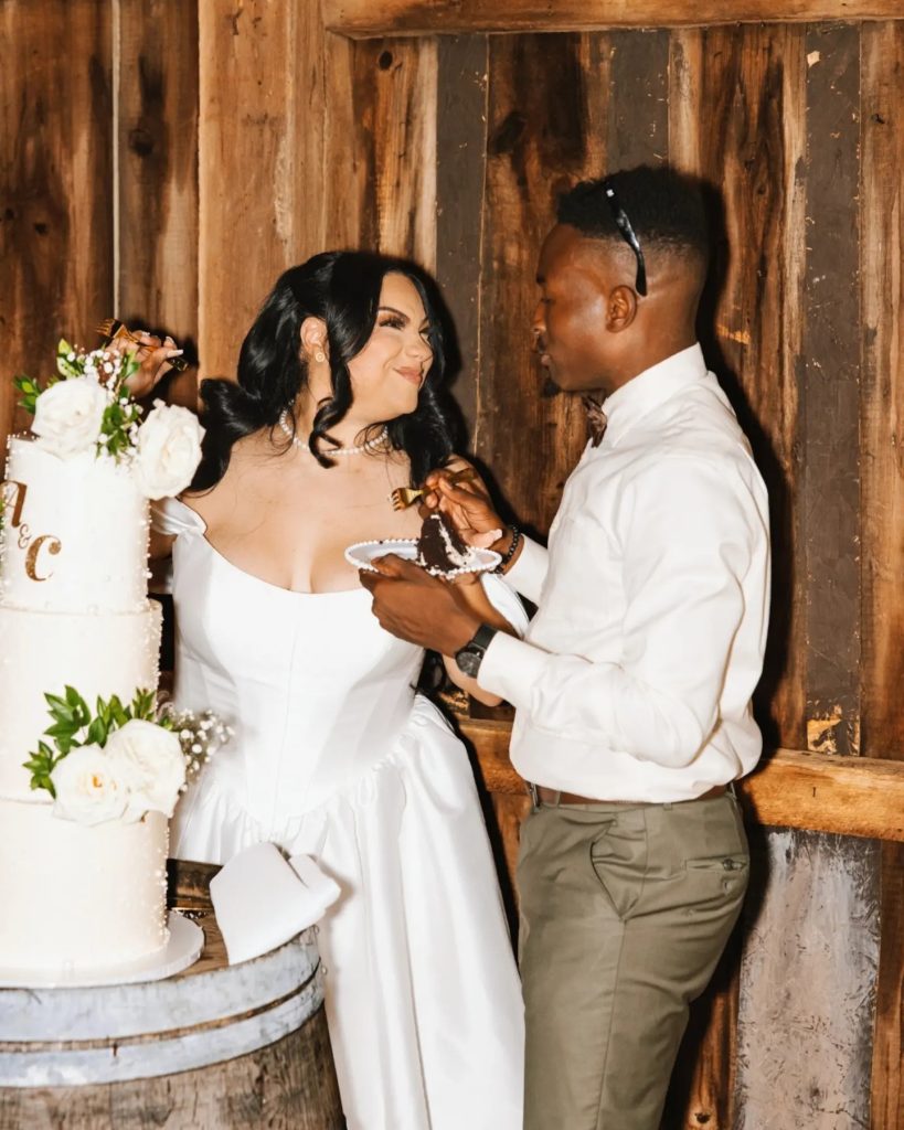 couple cutting tiered wedding cake at barn wedding at upscale wedding reception venue in northern virginia