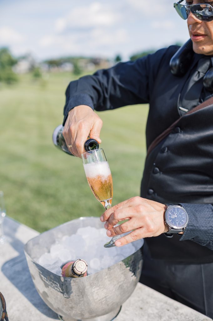 catering pouring champagne to make signature cocktail