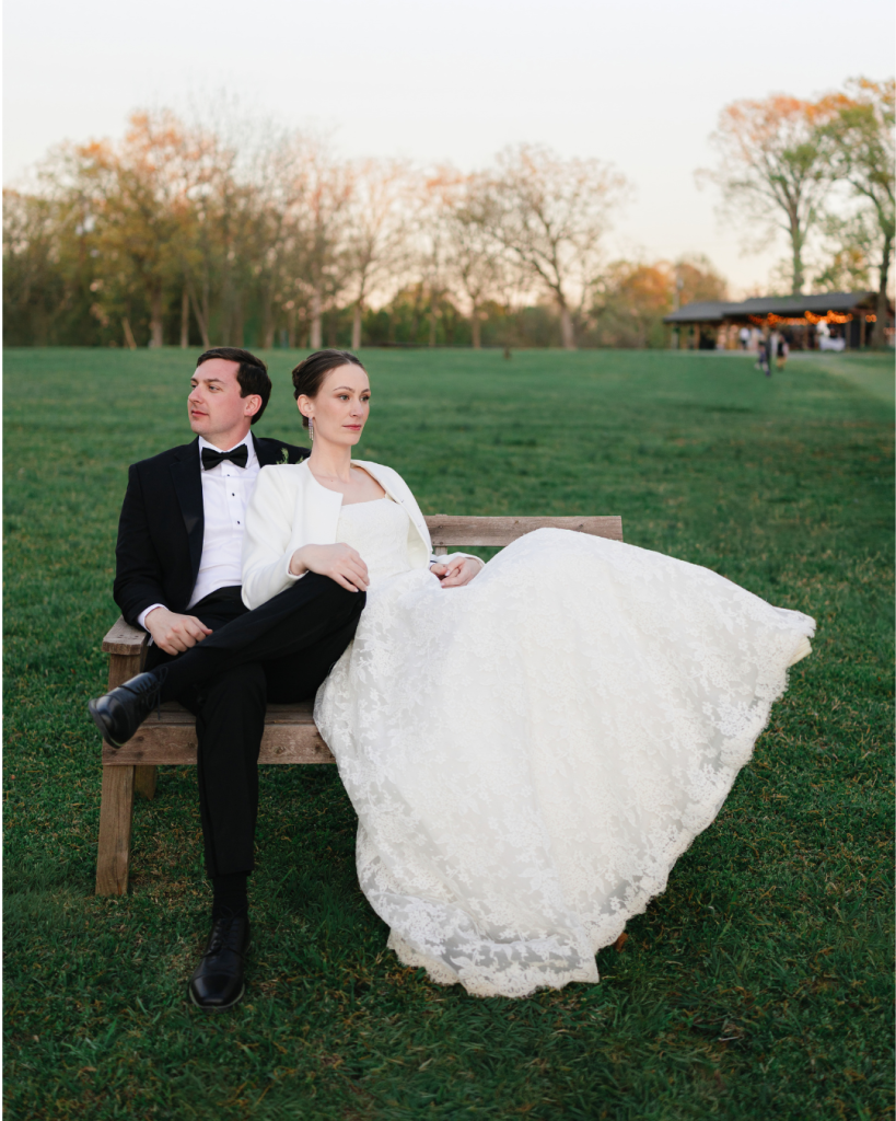 ate and Alex pose together on a wooden bench in black tie wedding attire at The Union Exchange in Monroe, North Carolina.