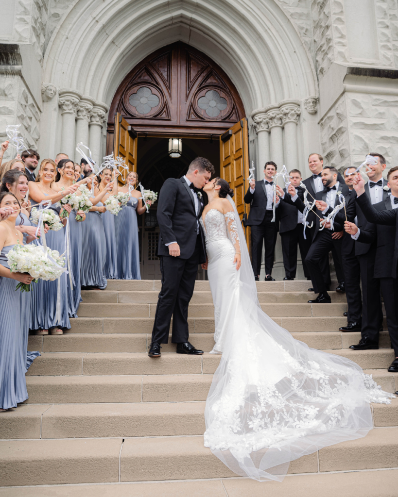 bride and groom ceremony exit with bridesmaids and groomsmen waving ribbon