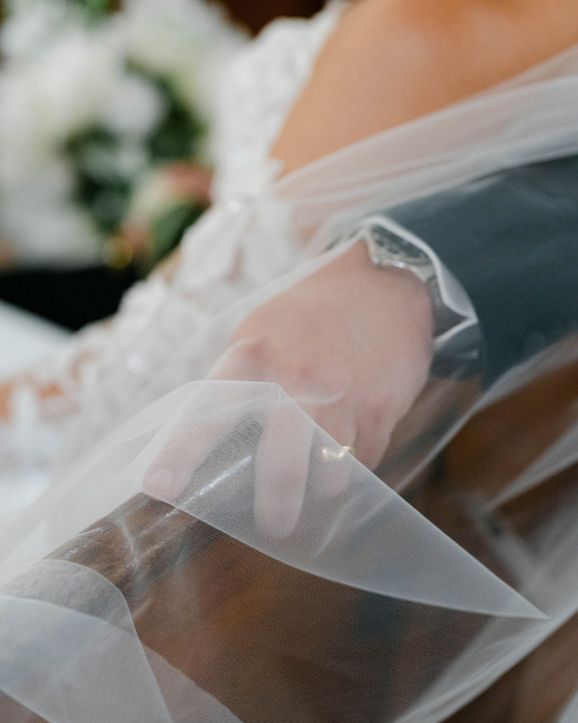 photo of bride and groom sitting in church pew