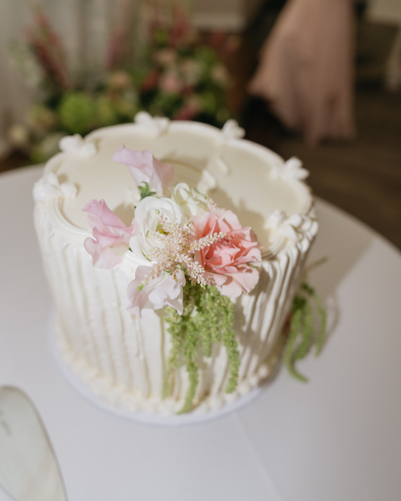 textured small circular cake with pastel florals tier