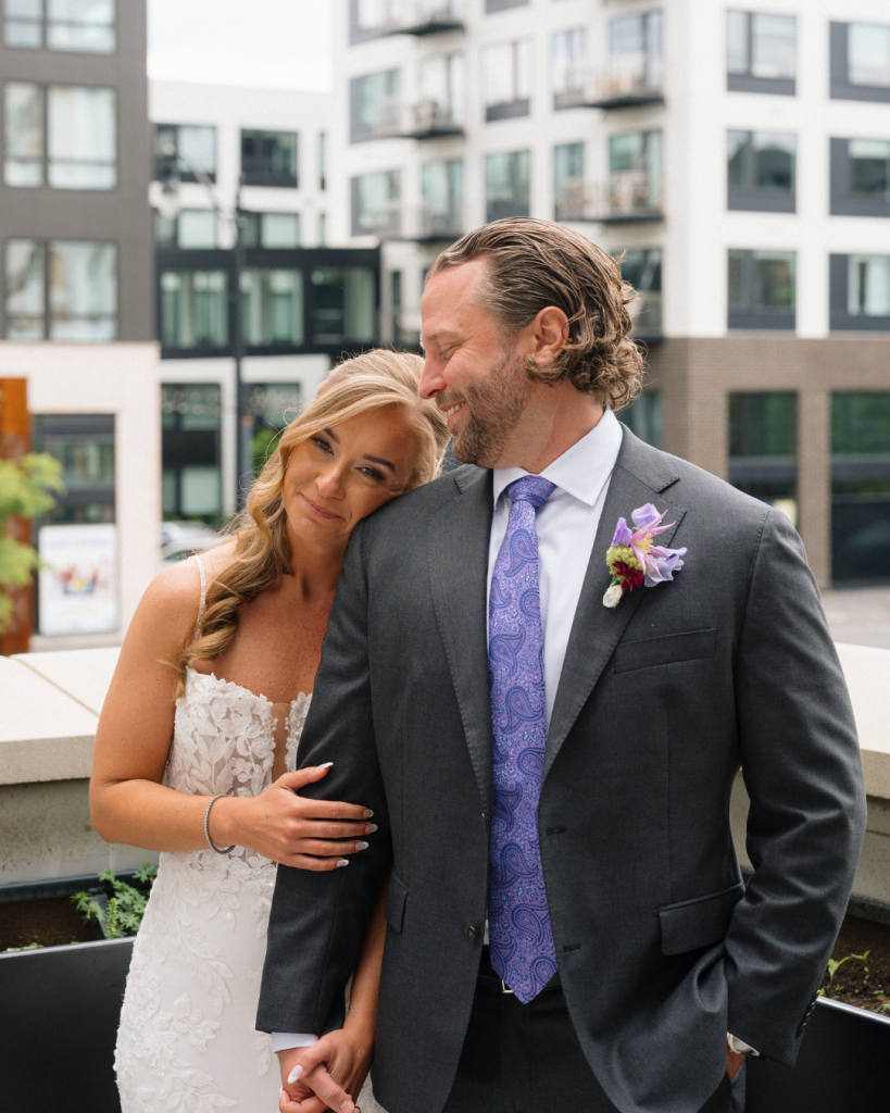 Newlyweds Chelsea and Matt pose together in wedding attire outside The Junto in downtown Columbus, Ohio.