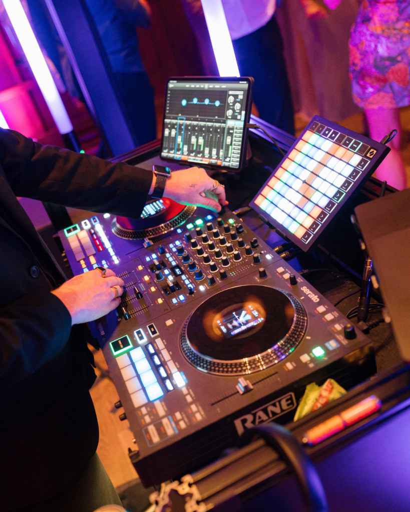 Wedding DJ operating professional sound equipment and colorful lighting during a Columbus wedding reception.