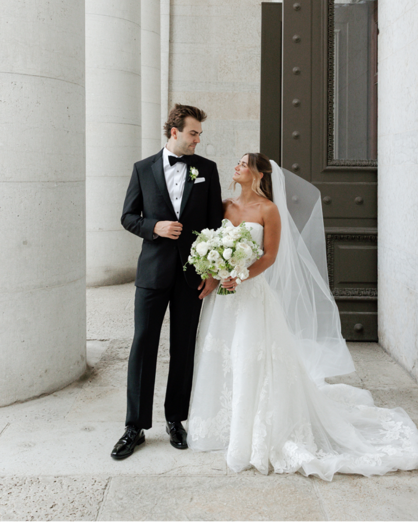2026 Wed Society Columbus Wedding of the Year winners Hannah and Ben pose outside The Ohio Statehouse in wedding attire