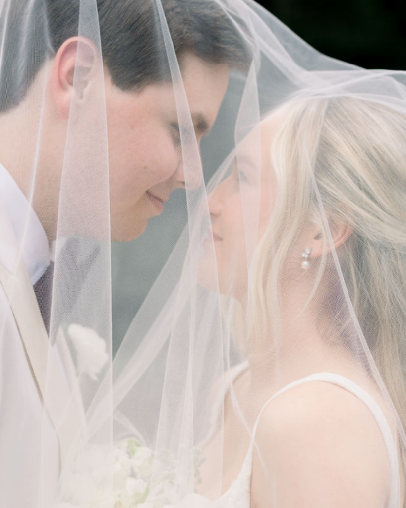 Elizabeth and Carter share a close portrait beneath her sheer bridal veil during their Columbus wedding celebration.